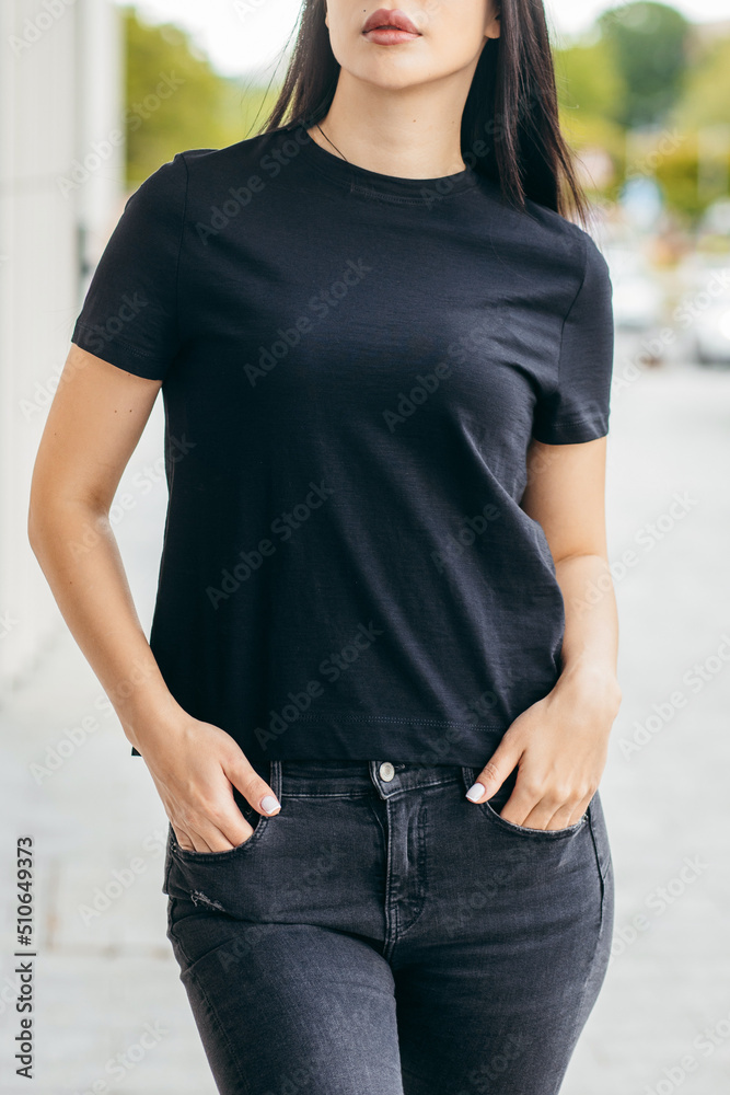 Wall mural Stylish brunette asian girl wearing black t-shirt posing against street , urban clothing style. Street photography