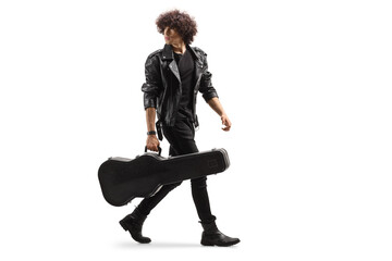 Full length shot of a rocker in a leather jacket walking and carrying a guitar in a case