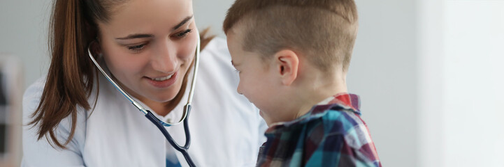 Young woman pediatrician listen kid with stethoscope tool on planned checkup