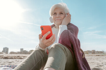 Joyous female listening to music on the beach