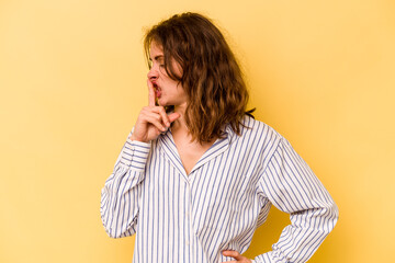 Young caucasian woman isolated on yellow background keeping a secret or asking for silence.