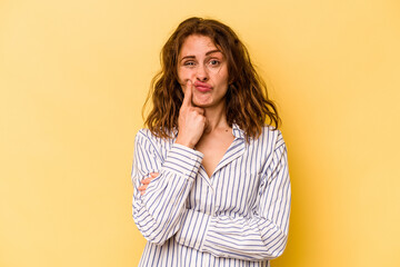 Young caucasian woman isolated on yellow background unhappy looking in camera with sarcastic expression.