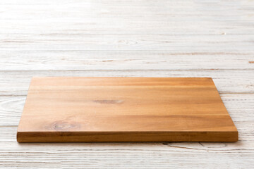 Perspective view of wooden cutting board on wooden background. Empty space for your design