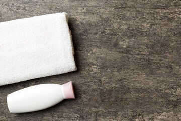Cosmetic shampoo bottle mockup with towels on a colored table. Bathroom background, toilet accessories for hand and body care