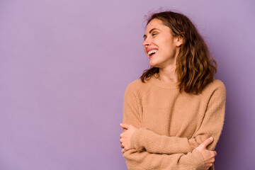 Young caucasian woman isolated on purple background smiling confident with crossed arms.