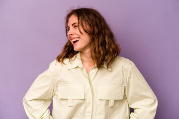 Young caucasian woman isolated on purple background confident keeping hands on hips.