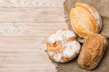 Assortment of freshly baked bread with napkin on rustic table top view. Healthy unleavened bread. French bread