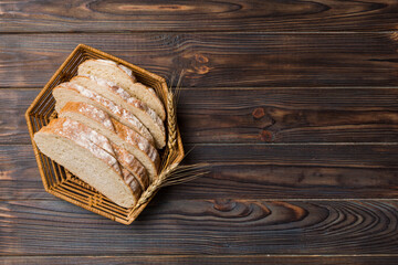 Freshly baked bread slices on basket against natural background. top view Sliced bread