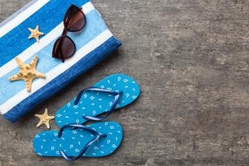 Summer travel concept. Flip flops, sunglasses and starfish on white. Top view on colored background