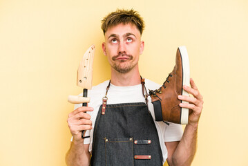 Young shoemarket man isolated on yellow background