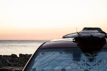 Fototapeta na wymiar surfboard on the roof of a van, let the road trip begin