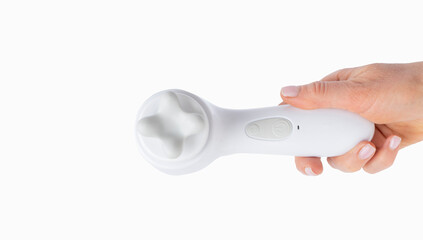 A woman's hand holds a daily massage device on an isolated background. The concept of beauty and care for healthy and young facial skin