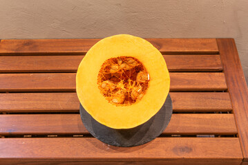 Half of a ripe pumpkin on wooden plank table