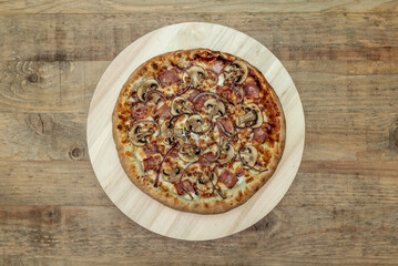 Baked Italian pizza with lots of mushrooms, lots of bacon, red onion and mozzarella cheese