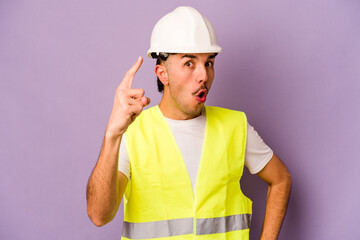 Young hispanic worker man isolated on purple background having an idea, inspiration concept.