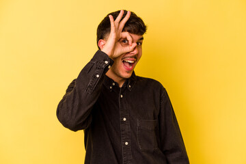 Obraz premium Young caucasian man isolated on yellow background excited keeping ok gesture on eye.