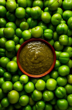 Tkemali sauce, traditional Georgian cuisine, green cherry plum, on a wooden table, close-up, rustic, food background, no people, selective focus,