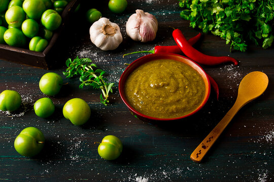 Tkemali sauce, traditional Georgian cuisine, green cherry plum, on a wooden table, close-up, rustic, food background, no people, selective focus,