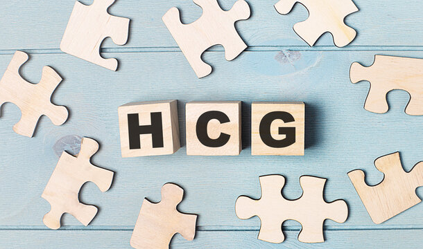 Blank puzzles and wooden cubes with the text HCG Human Chorionic Gonadotrophin lie on a light blue background.