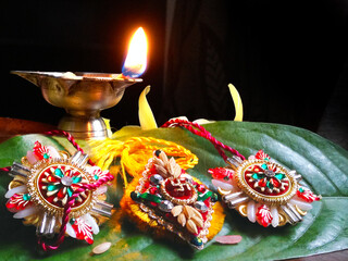 Rakhi placed with oil lamps during Raksha Bandhan festival in Maharashtra, India.