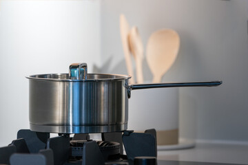 stainless steel pot on electronic modern flat stove in low light on counter kitchen room
