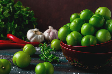 Tkemali, green cherry plum, with ingredients for sauce, on a wooden table, close-up, rustic, food background, no people, selective focus,