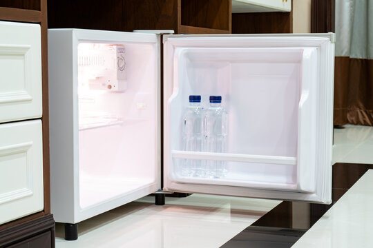 Refrigerator Fridge Mini Size Under The Table Counter With Wooden Desk Beside It In Hotel Delux Room.