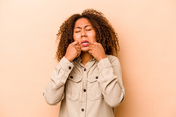 Young African American woman isolated on beige background whining and crying disconsolately.