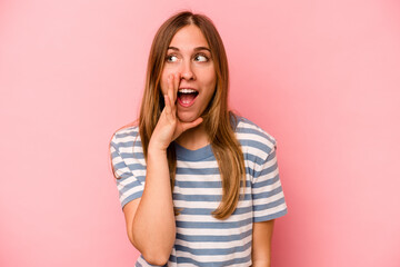 Young caucasian woman isolated on pink background shouting excited to front.