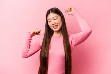 Young Chinese woman isolated on pink background celebrating a special day, jumps and raise arms with energy.