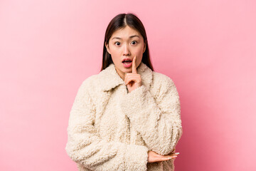 Young Chinese woman isolated on pink background having some great idea, concept of creativity.