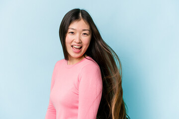 Obraz premium Young asian woman moving hair isolated on blue background