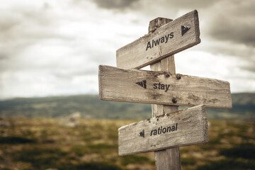 always stay rational text quote on wooden signpost outdoors in nature. Inflation, economy and finance concept.