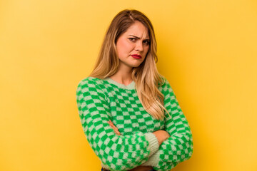 Young caucasian woman isolated on yellow background suspicious, uncertain, examining you.