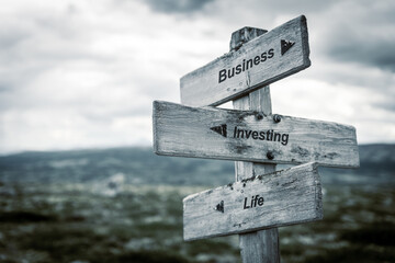 business investment life text quote on wooden signpost outdoors in nature. , economy and finance concept.