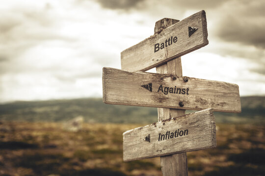 battle against inflation text quote on wooden signpost outdoors in nature. Inflation, economy and finance concept.