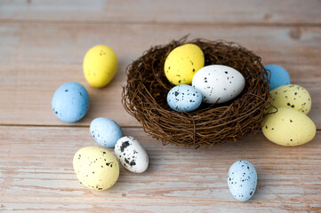 Nest filled with white,yellow and blue eggs. Happy easter banner with place for text