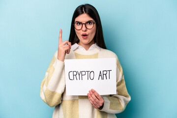Fototapeta na wymiar Young caucasian business woman holding a crypto art placard isolated on blue background having some great idea, concept of creativity.