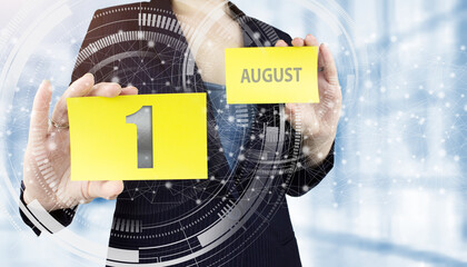 August 1st . Day 1 of month, Calendar date. Business woman hand hold yellow sheet with calendar...