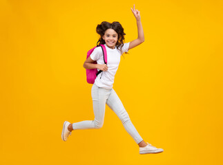 Amazed teen girl. Schoolgirl in school uniform with school bag. Schoolchild, teen student hold backpack on yellow isolated background. Run and jump. Excited expression, cheerful and glad.