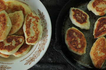 fried pies on a plate and a frying pan. top view