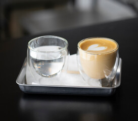 latte cup of coffee on a table with the drinking water
