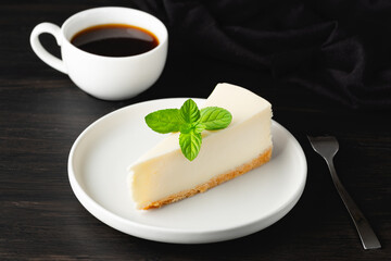 Cheesecake and cup of black coffee on a wooden table. 