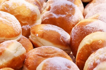 Freshly baked buns in powdered sugar on the counter of a bakery shop