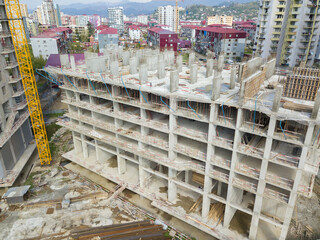 Close-up view from a drone on the construction of a multi-storey building in summer