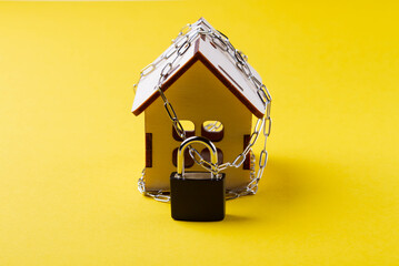 Housing arrest. Castle house. Small toy house and a chain with a lock.