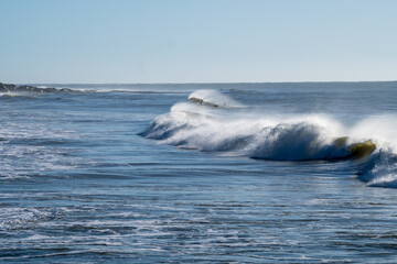 Beautiful beach with rough seas and strong waves crashing against the rocks