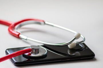Red stethoscope on black smartphone represents health records and digital patient records with mobile devices for digital doctors and digital diagnostic treatment with modern equipment and technology