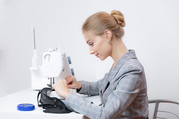 Seamstress tailor woman working on sewing machine lace bra lingerie, white background