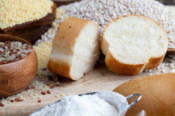 wheat baguette on the table with flour and various plant grains